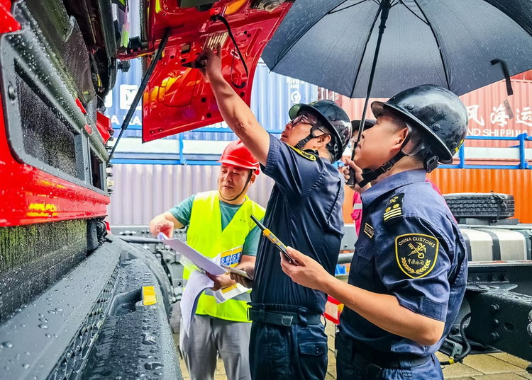 新沙海关关员对一批进口重型卡车进行查验，护航车辆质量安全